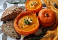 Creamy pumpkin soup and homemade bread on grey tiled table. Soup in a squash top view photo. Thanksgiving menu ideas.ÃÂ ÃÂ  Royalty Free Stock Photo